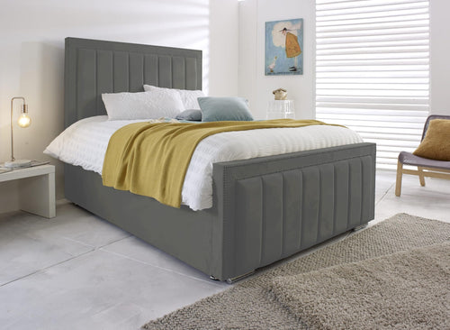 Grey velvet Bumper Panel Bed with tall vertical-panel headboard and matching footboard in a bright bedroom