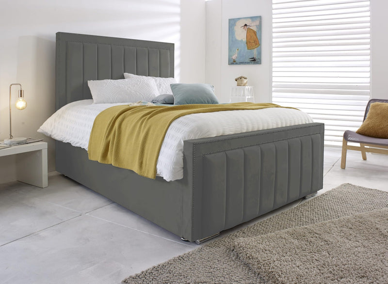 Grey velvet Bumper Panel Bed with tall vertical-panel headboard and matching footboard in a bright bedroom