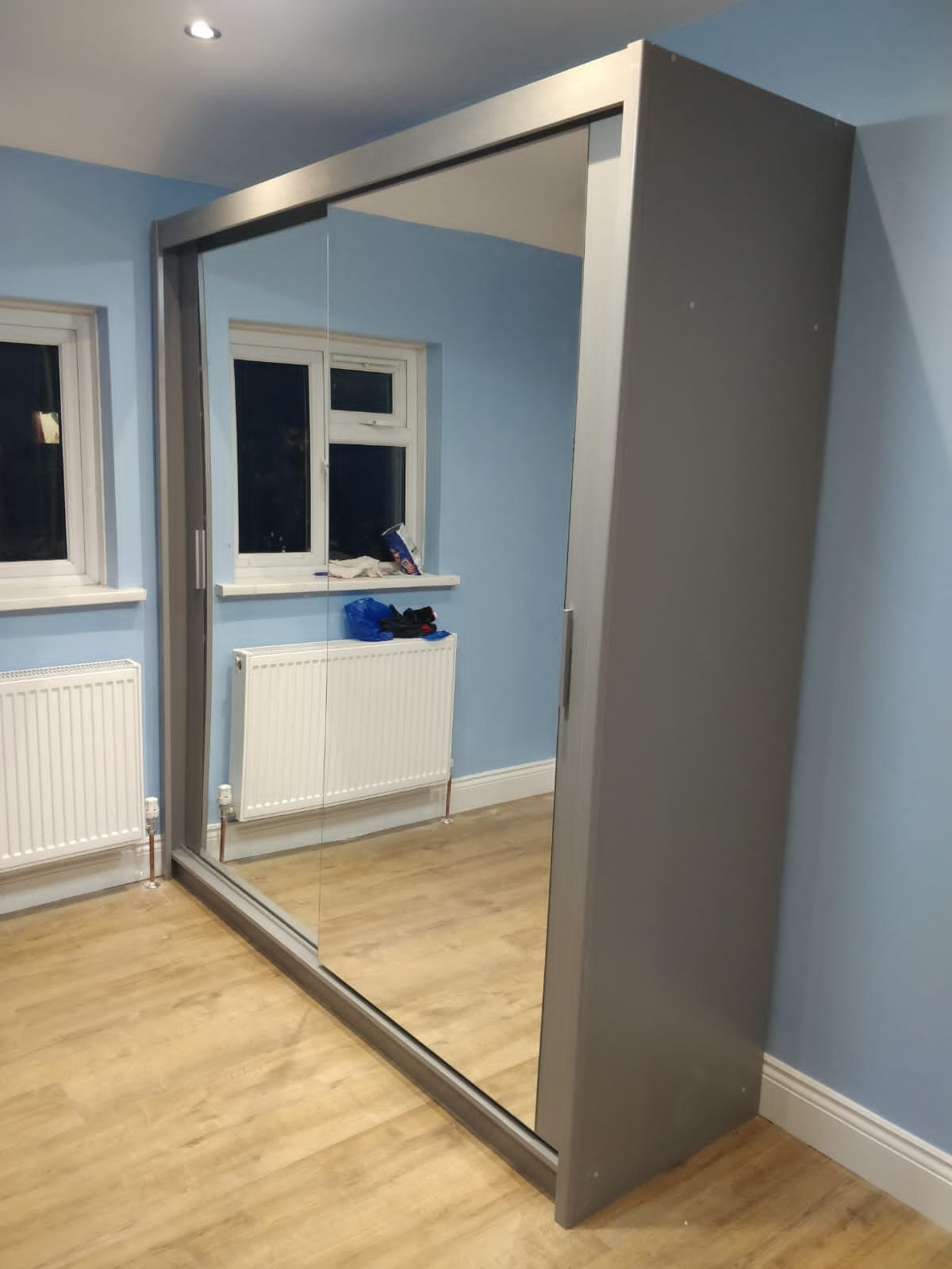 Grey sliding wardrobe with full-length mirrored doors
